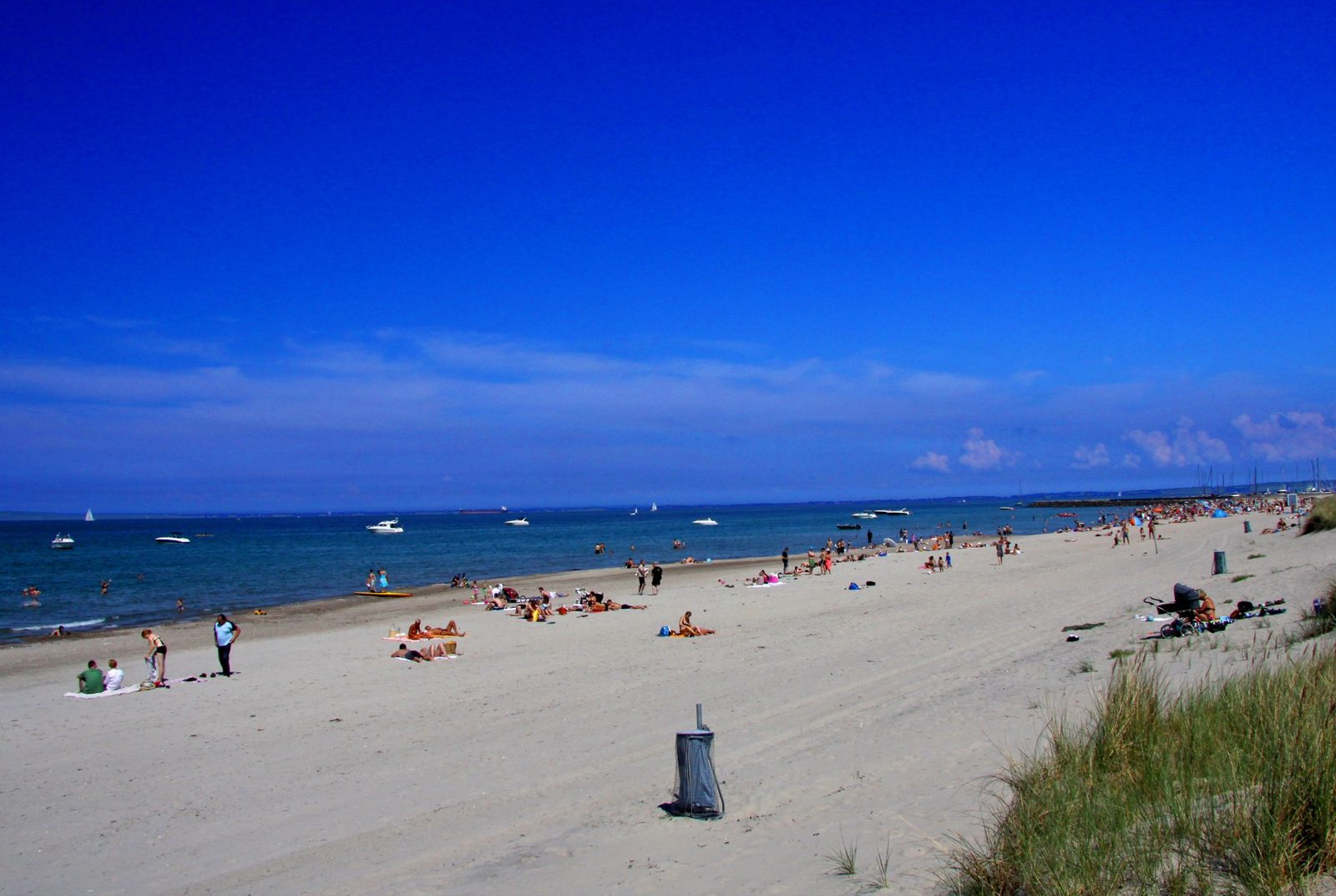 Hornbæk Strand en sommerdag med klitter, sand og sejlbåde ud for havnen