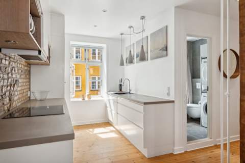 Open kitchen and living space with rare historic Copenhagen brick from the 1700s