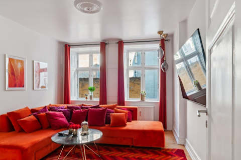 Living room with a luxurious double sofa bed that transforms into a private bedroom when closed off.