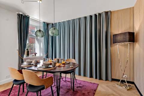 A large curtain separating the living room from the sofa bed area, ensuring privacy for guests who sleep on the sofa bed.”