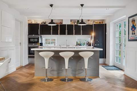 A cozy kitchen centered around the island and bar stools, designed for togetherness, good food and unhurried moments.