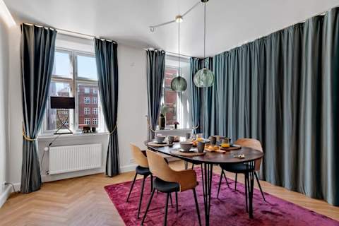 A large curtain separating the living room from the sofa bed area, ensuring privacy for guests who sleep on the sofa bed.”
