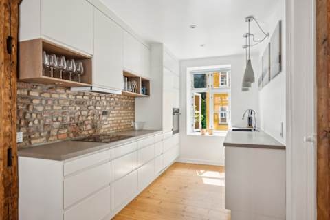 Open kitchen and living space with rare historic Copenhagen brick from the 1700s