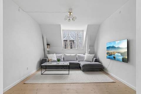 Bright and cozy living room with plenty of natural light, comfortable seating, and a large TV perfect for relaxing evenings. The sofa can also easily be converted into a comfortable sofa bed with space for 2 guests.