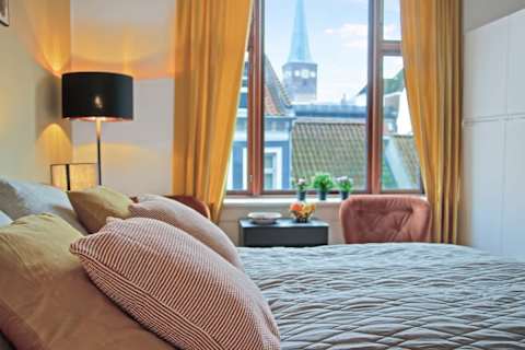 Elegant and spacious bedroom with a luxurious king-size bed, refined décor, generous storage, and a large flat-screen TV. A calm, high-end retreat designed for comfort and relaxation in central Aarhus.