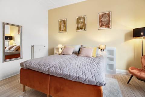 Spacious and serene bedroom featuring a luxurious king-size bed that can be separated into two single beds upon request, elegant décor, and generous storage. The perfect retreat to unwind after a day in the heart of Aarhus.