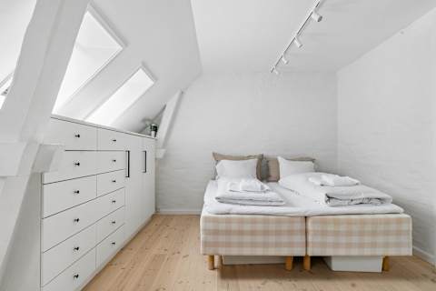 Cozy and peaceful bedroom with a comfortable double bed, soft natural light, and a calm atmosphere perfect for relaxing after a day exploring Copenhagen.
