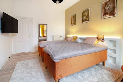 Spacious and serene bedroom featuring a luxurious king-size bed that can be separated into two single beds upon request, elegant décor, and generous storage. The perfect retreat to unwind after a day in the heart of Aarhus.