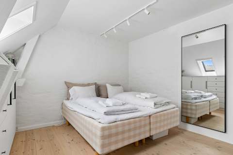 Cozy and peaceful bedroom with a comfortable double bed, soft natural light, and a calm atmosphere perfect for relaxing after a day exploring Copenhagen.