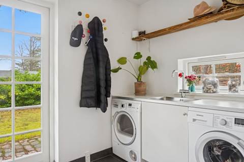A practical yet refined utility room with washing machine and tumble dryer — designed to make longer stays effortless and comfortable.