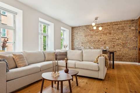 Bright living area and open kitchen with original Copenhagen brick wall from the 1700s
