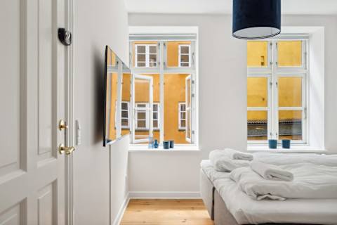 Bright and Calm bedroom with a queen-size bed and TV, perfect for relaxing after a day in the city. A peaceful and cozy space designed for a great night’s sleep.