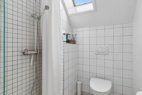 Clean and functional bathroom with shower, toilet, and fresh towels provided