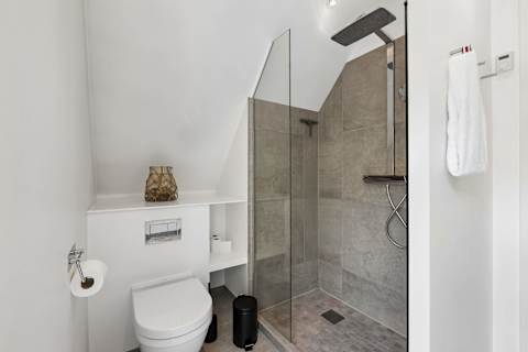 A stylish bathroom with a luxurious rain shower and direct access to a private terrace—perfect for starting your day or unwinding after the beach.