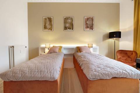 Spacious and serene bedroom featuring a luxurious king-size bed that can be separated into two single beds upon request, elegant décor, and generous storage. The perfect retreat to unwind after a day in the heart of Aarhus.