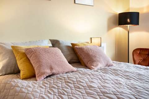 Spacious and serene bedroom featuring a luxurious king-size bed that can be separated into two single beds upon request, elegant décor, and generous storage. The perfect retreat to unwind after a day in the heart of Aarhus.
