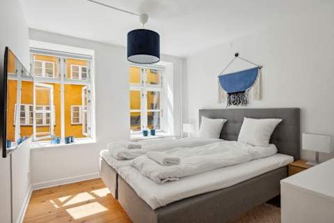 Bright and Calm bedroom with a queen-size bed and TV, perfect for relaxing after a day in the city. A peaceful and cozy space designed for a great night’s sleep.