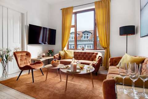 Beautiful, spacious living area with a sophisticated atmosphere and plenty of natural light. Enjoy a large flat-screen TV, comfortable seating, and a dining table perfect for relaxed dinners and social evenings.