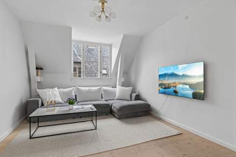 Bright and cozy living room with plenty of natural light, comfortable seating, and a large TV perfect for relaxing evenings. The sofa can also easily be converted into a comfortable sofa bed with space for 2 guests.