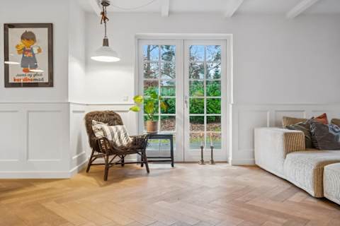 A bright and inviting living room with generous seating, soft textures and natural light — designed for relaxed afternoons, quiet evenings and shared moments together.
