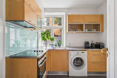 Start your morning with coffee in a clean, functional kitchen before stepping straight out into the vibrant city life.