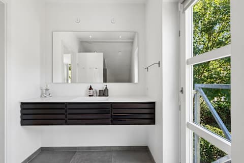 A stylish bathroom with a luxurious rain shower and direct access to a private terrace—perfect for starting your day or unwinding after the beach.