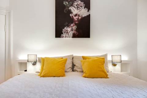 Elegant and spacious bedroom with a luxurious king-size bed, refined décor, generous storage, and a large flat-screen TV. A calm, high-end retreat designed for comfort and relaxation in central Aarhus.