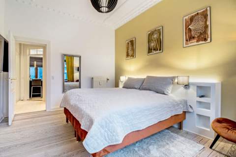 Spacious and serene bedroom featuring a luxurious king-size bed that can be separated into two single beds upon request, elegant décor, and generous storage. The perfect retreat to unwind after a day in the heart of Aarhus.