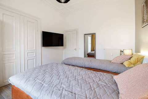 Spacious and serene bedroom featuring a luxurious king-size bed that can be separated into two single beds upon request, elegant décor, and generous storage. The perfect retreat to unwind after a day in the heart of Aarhus.