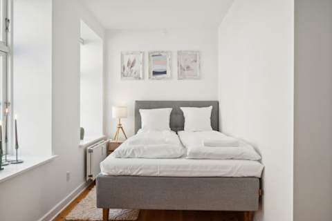 Bright and Calm bedroom with a queen-size bed and TV, perfect for relaxing after a day in the city. A peaceful and cozy space designed for a great night’s sleep.