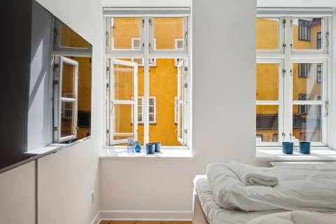 Bright and Calm bedroom with a queen-size bed and TV, perfect for relaxing after a day in the city. A peaceful and cozy space designed for a great night’s sleep.