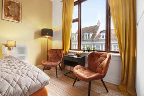 Spacious and serene bedroom featuring a luxurious king-size bed that can be separated into two single beds upon request, elegant décor, and generous storage. The perfect retreat to unwind after a day in the heart of Aarhus.